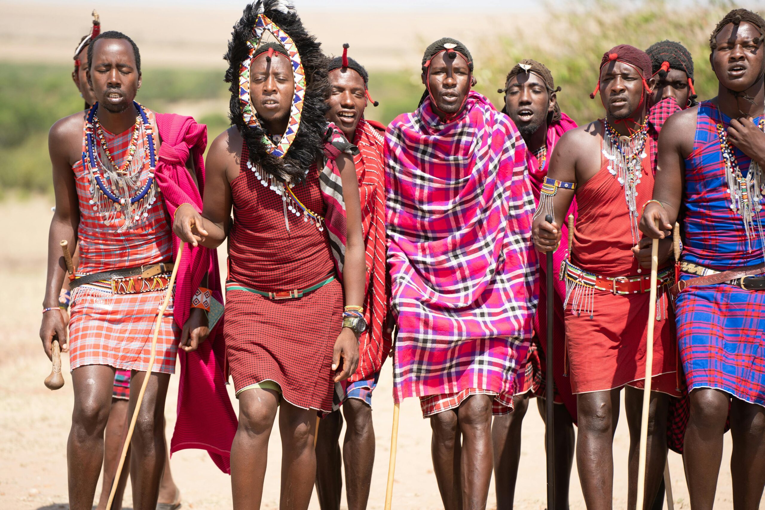 Masai warriors performing a traditional dance in vibrant attire, captured in Kenya.