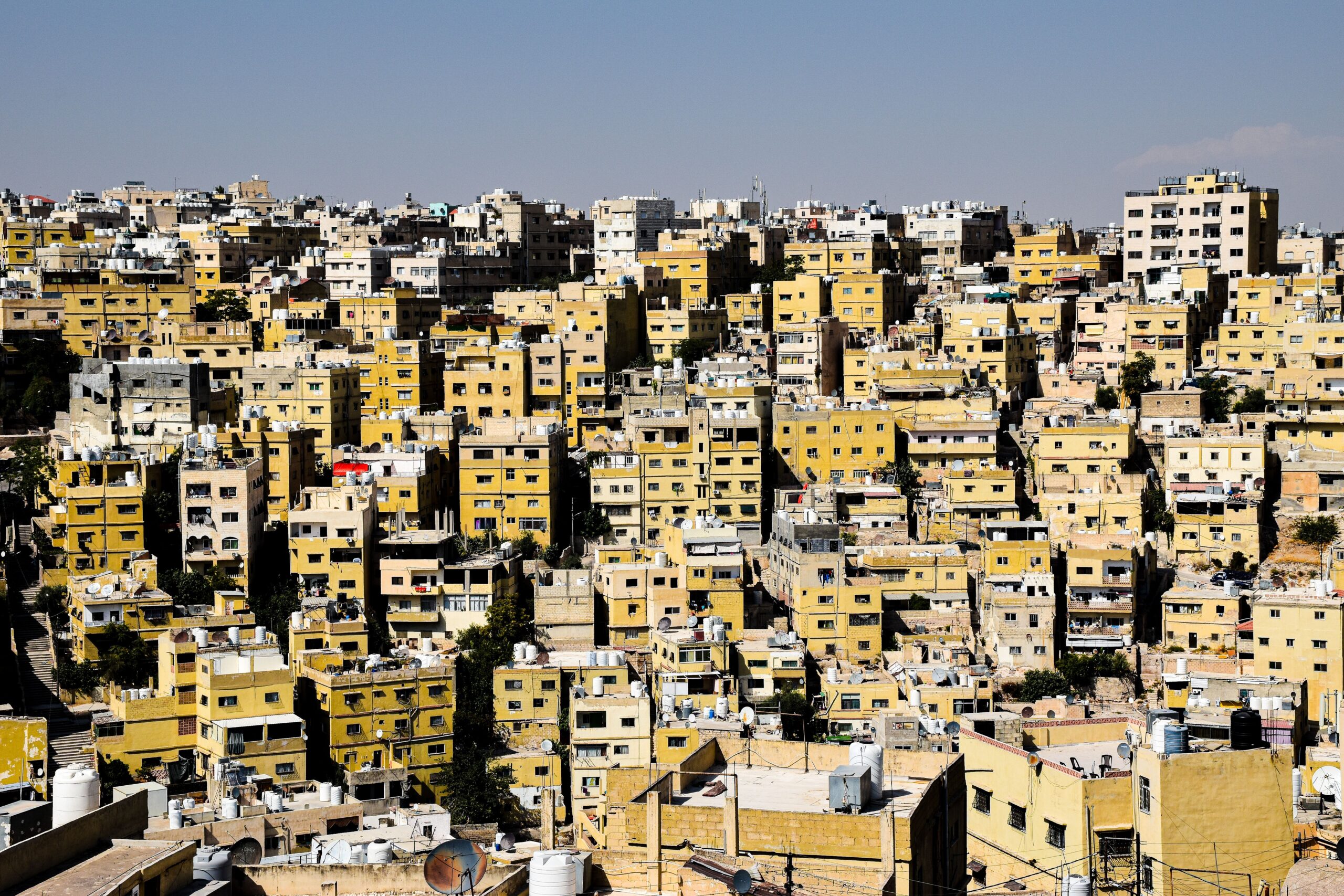 Aerial view capturing the densely packed urban buildings in Amman, Jordan, depicting a bustling cityscape.